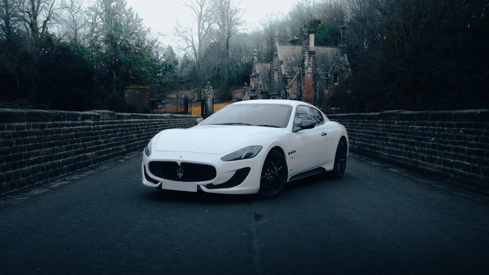 a white sports car parked on the side of a road