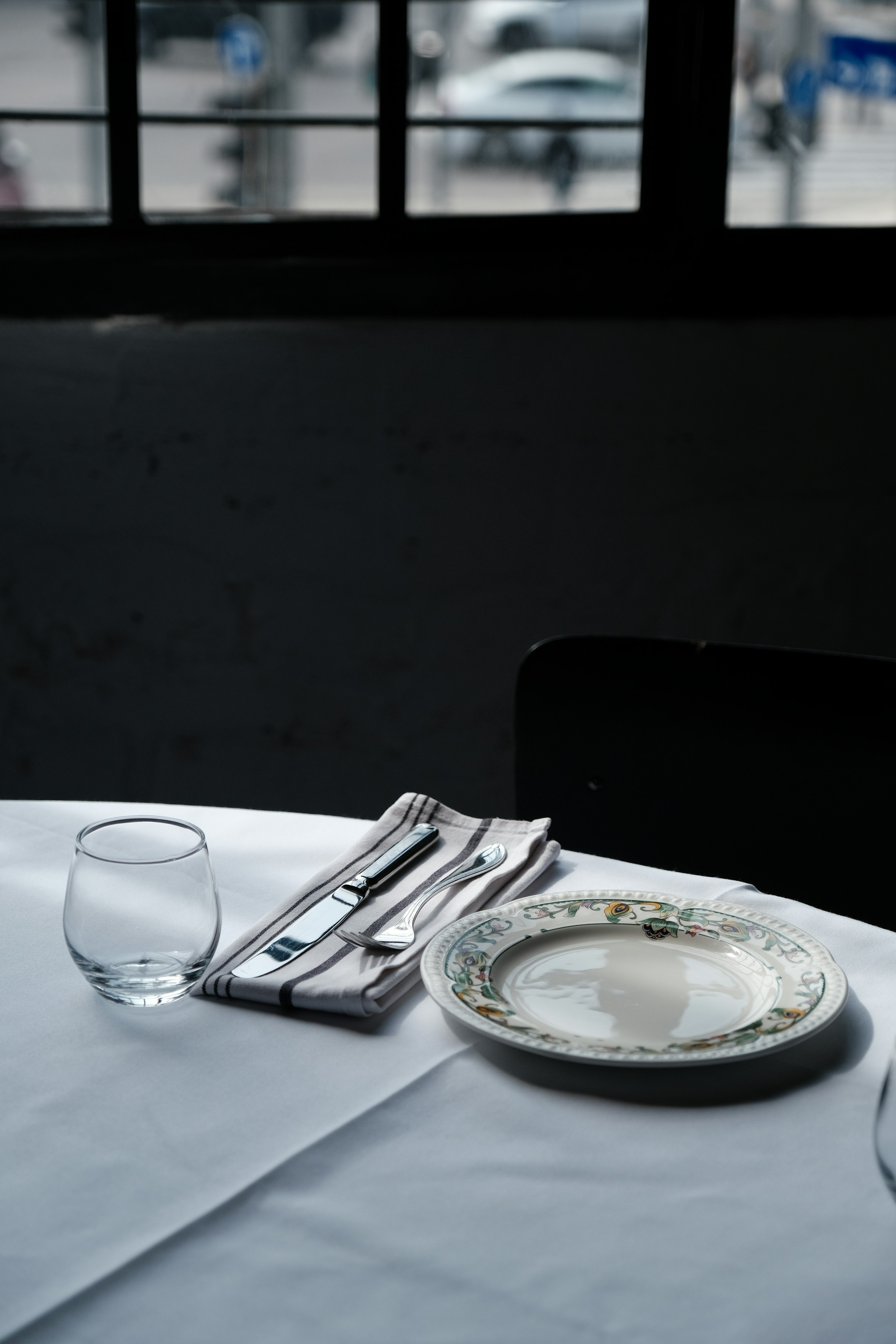 a white table with a plate and a glass on it