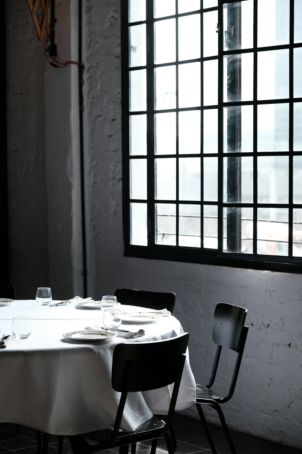 a table with a white table cloth and two black chairs