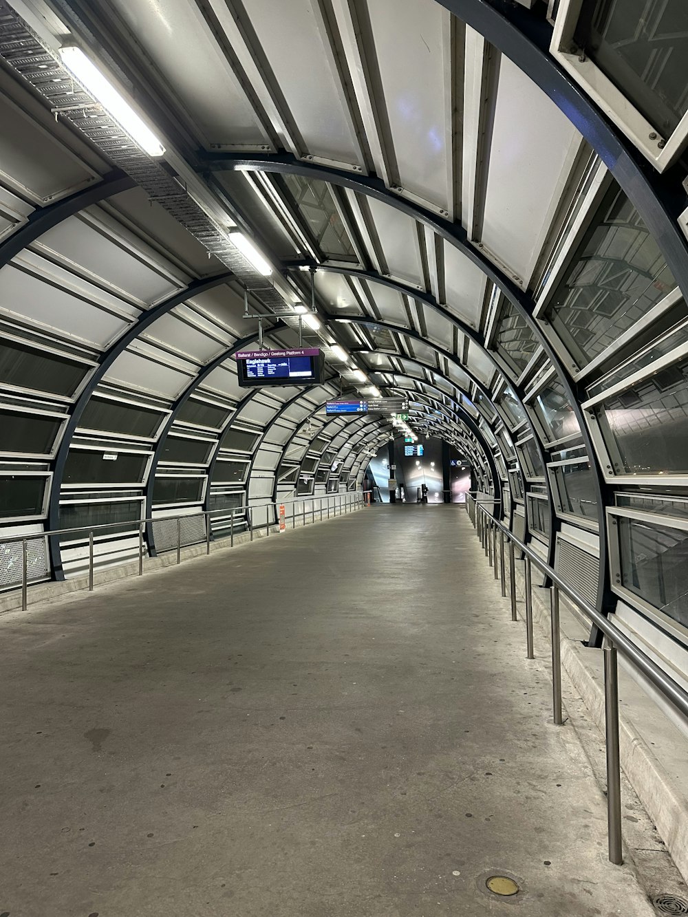 an empty subway station with metal railings