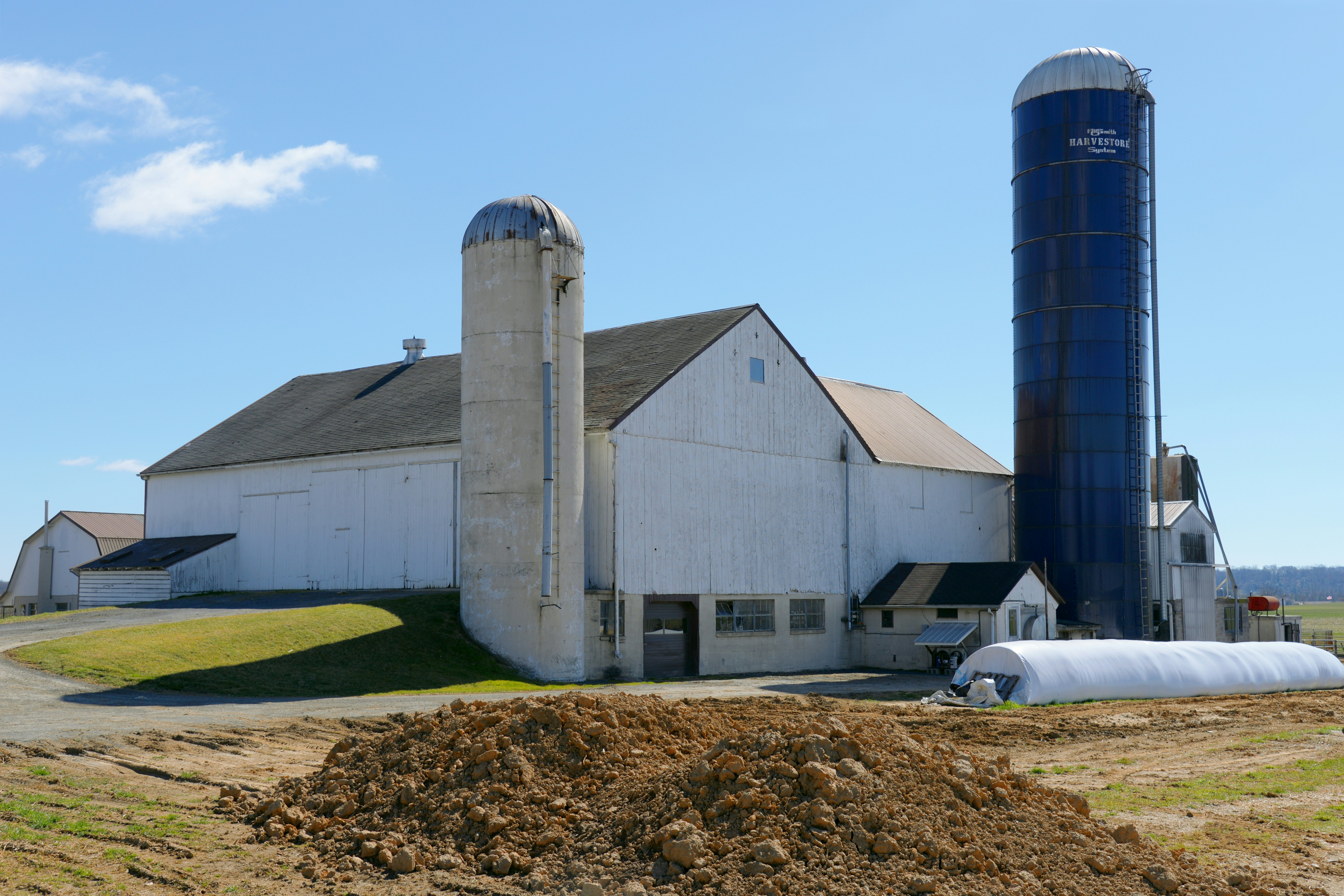 A farm with a large silo next to it photo – Free Image on Unsplash