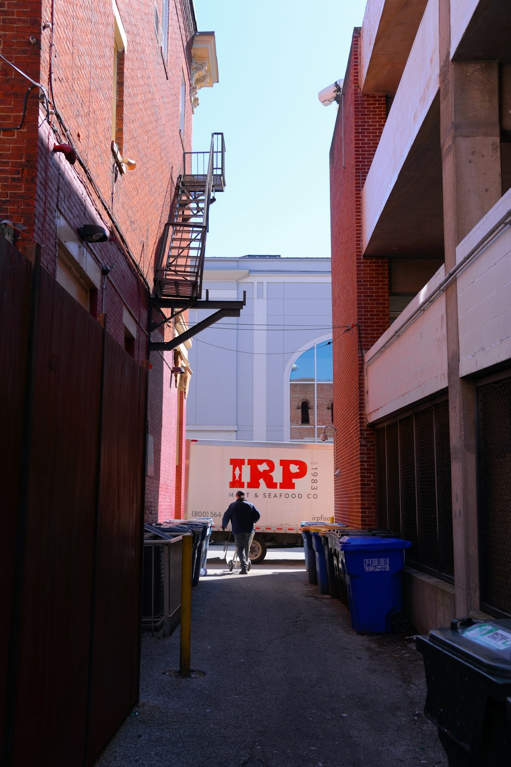 a narrow alley way with a moving truck in the background