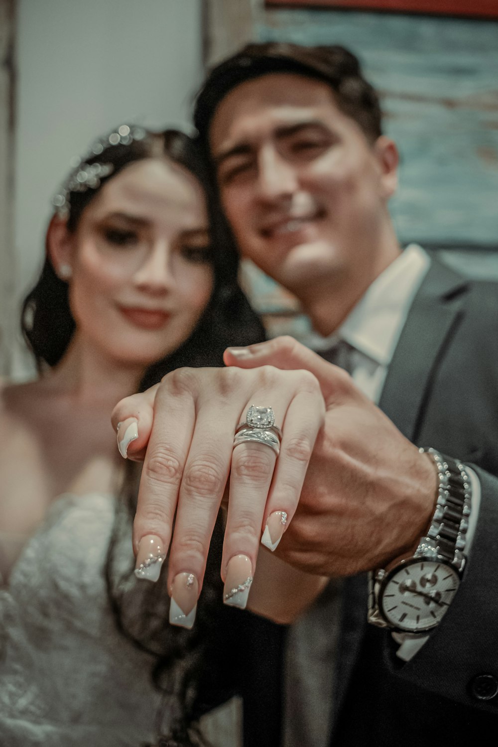 a bride and groom holding a wedding ring