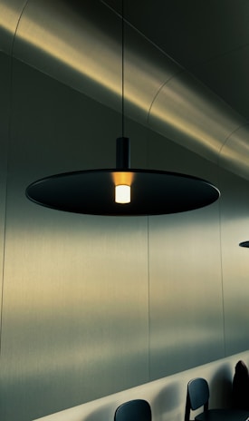Modern LED pendant lamp casting warm light over a minimalist dining table.