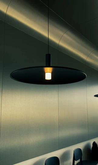 An elegant pendant lamp hanging over a minimalist workspace, creating a cozy ambiance.
