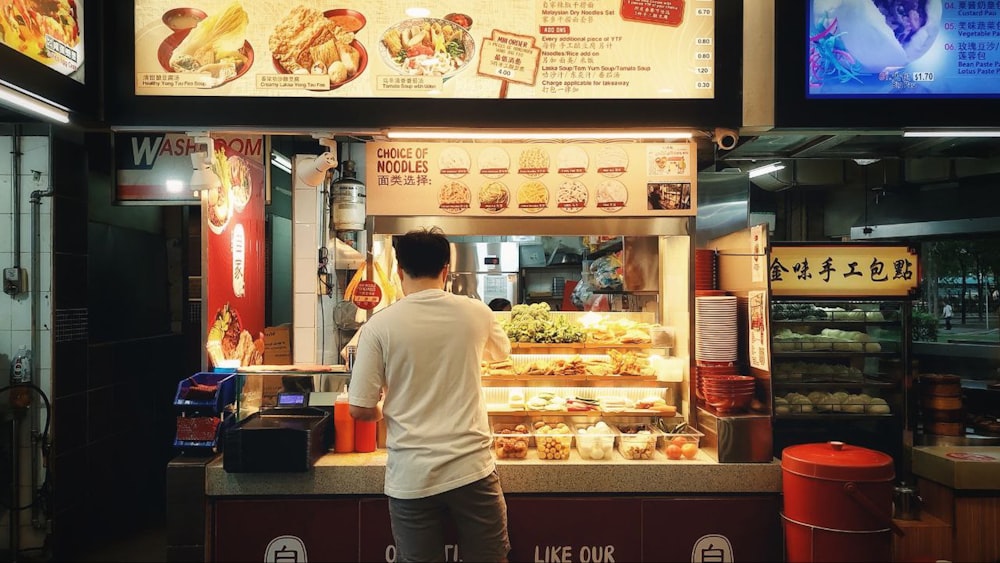 a man standing in front of a food stand