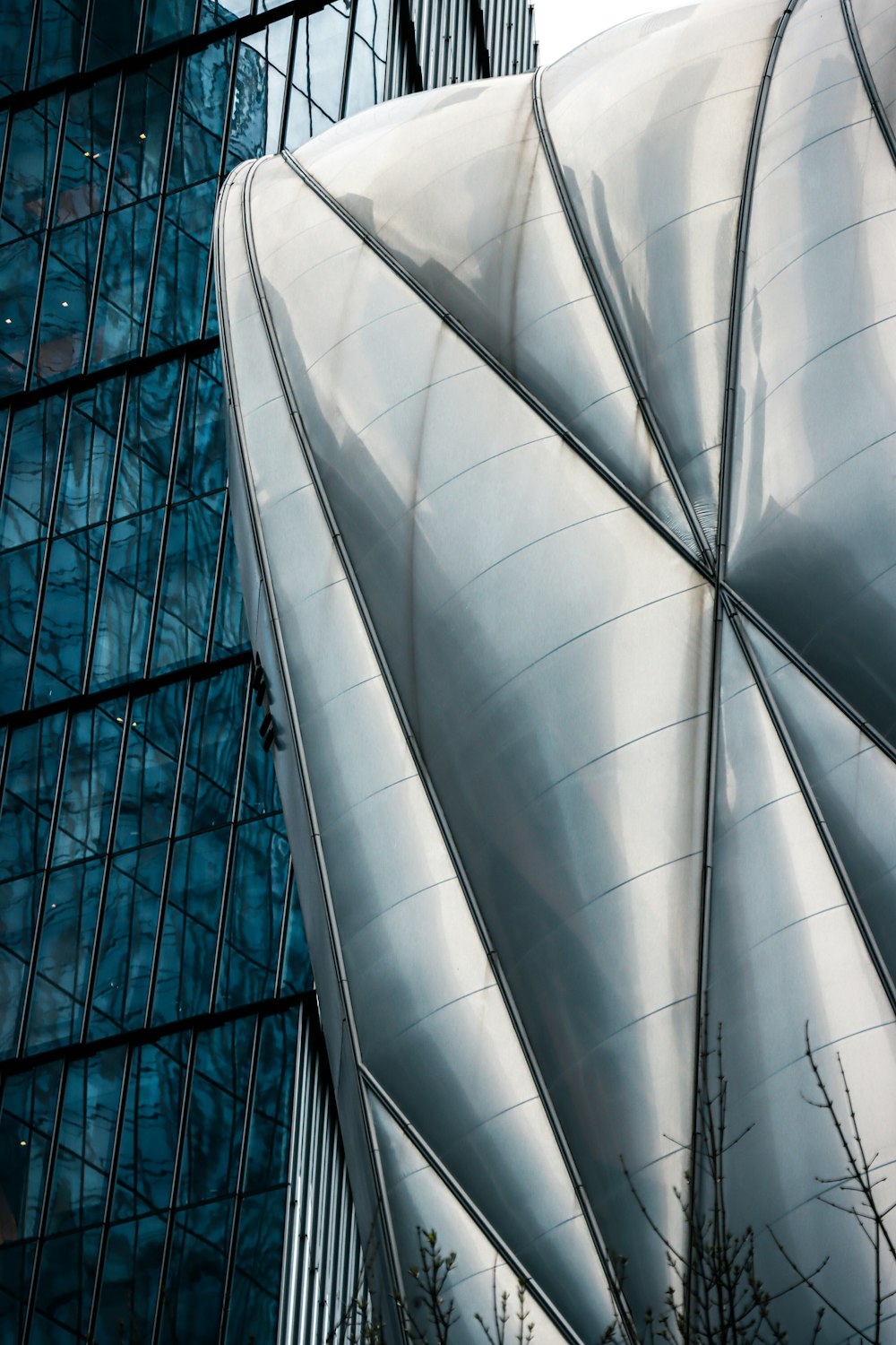 a tall building with a curved roof next to a tall building