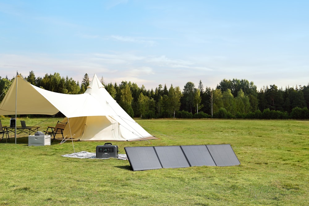 a large white tent sitting on top of a lush green field