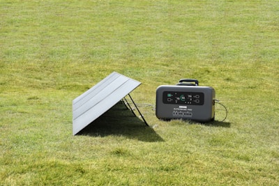 An outdoor scene showing a portable power station charging devices in the sunshine.