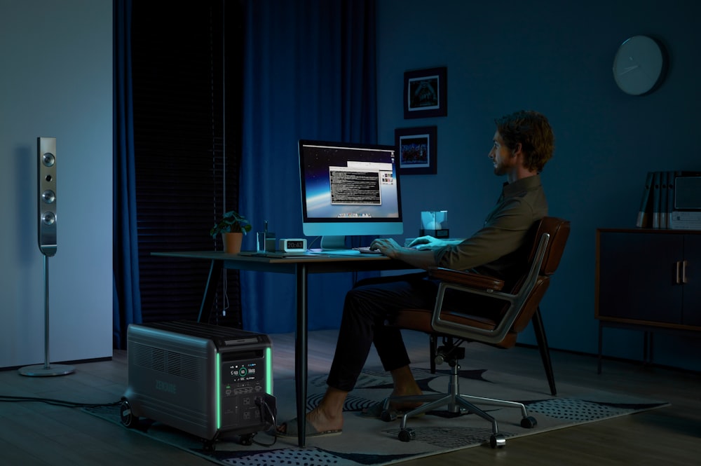 a man sitting at a desk in front of a computer