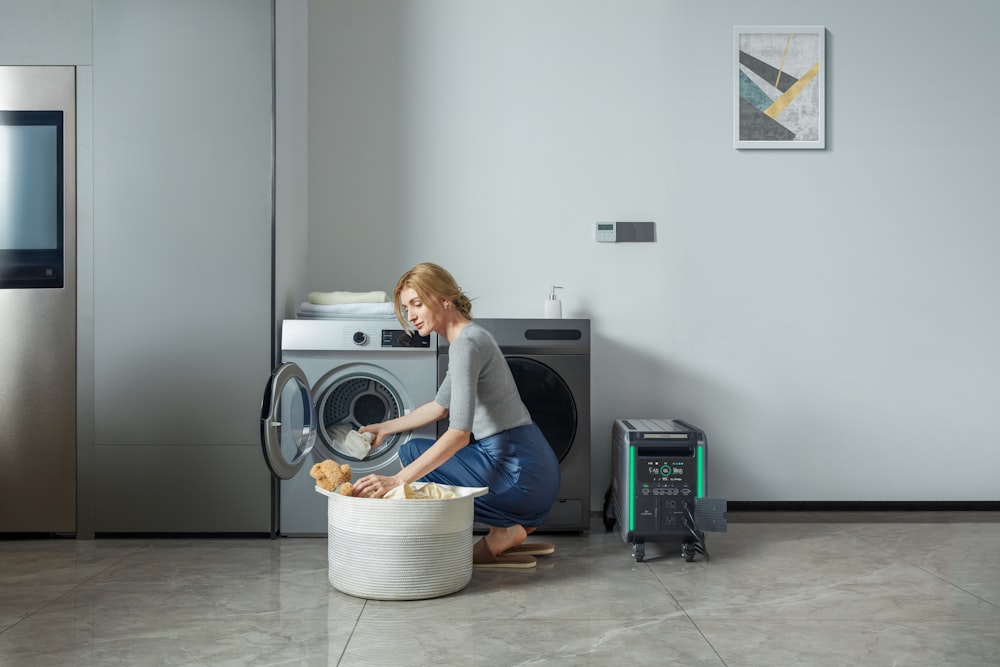 uma mulher carregando uma máquina de lavar roupa em um cesto de roupa