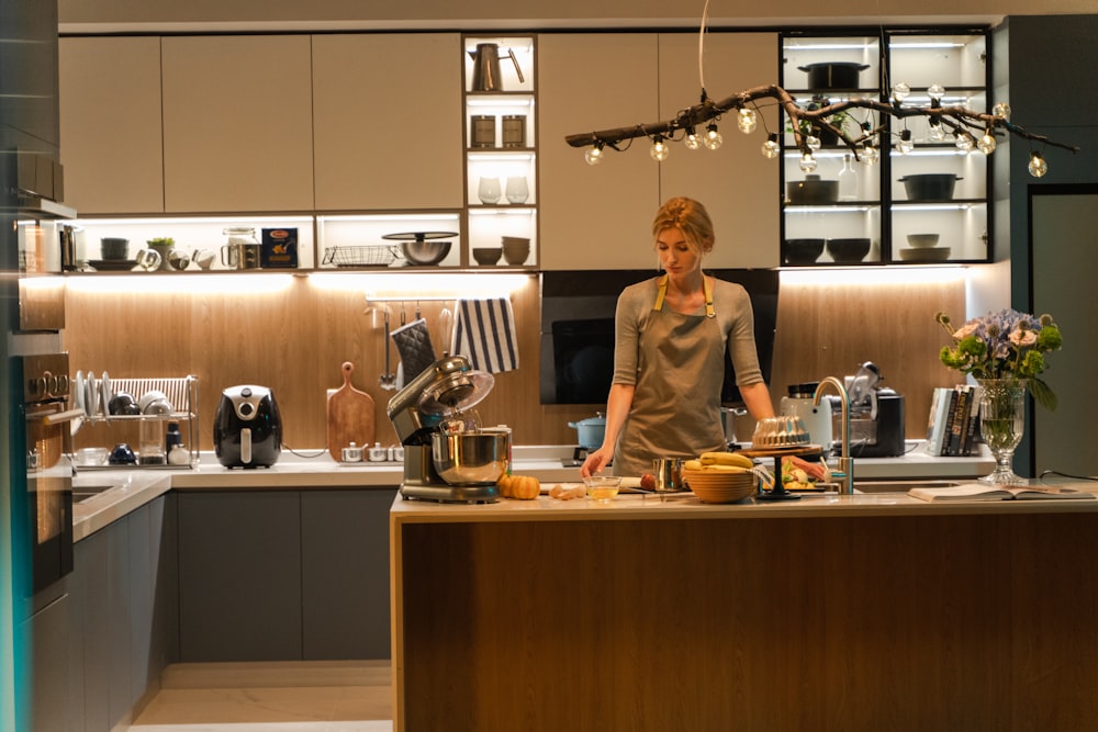 a woman standing in a kitchen preparing food