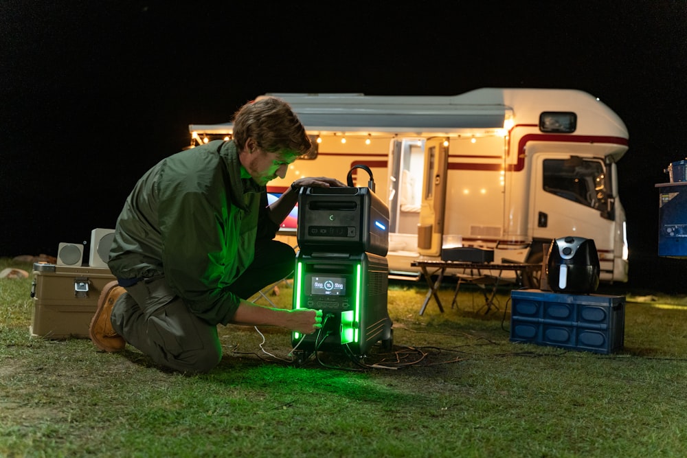 a man kneeling down next to a green light