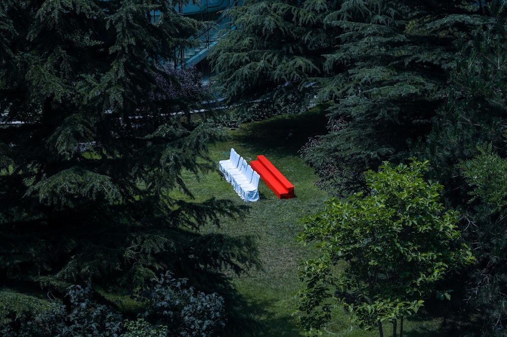 an aerial view of a red and white bench in the middle of a forest