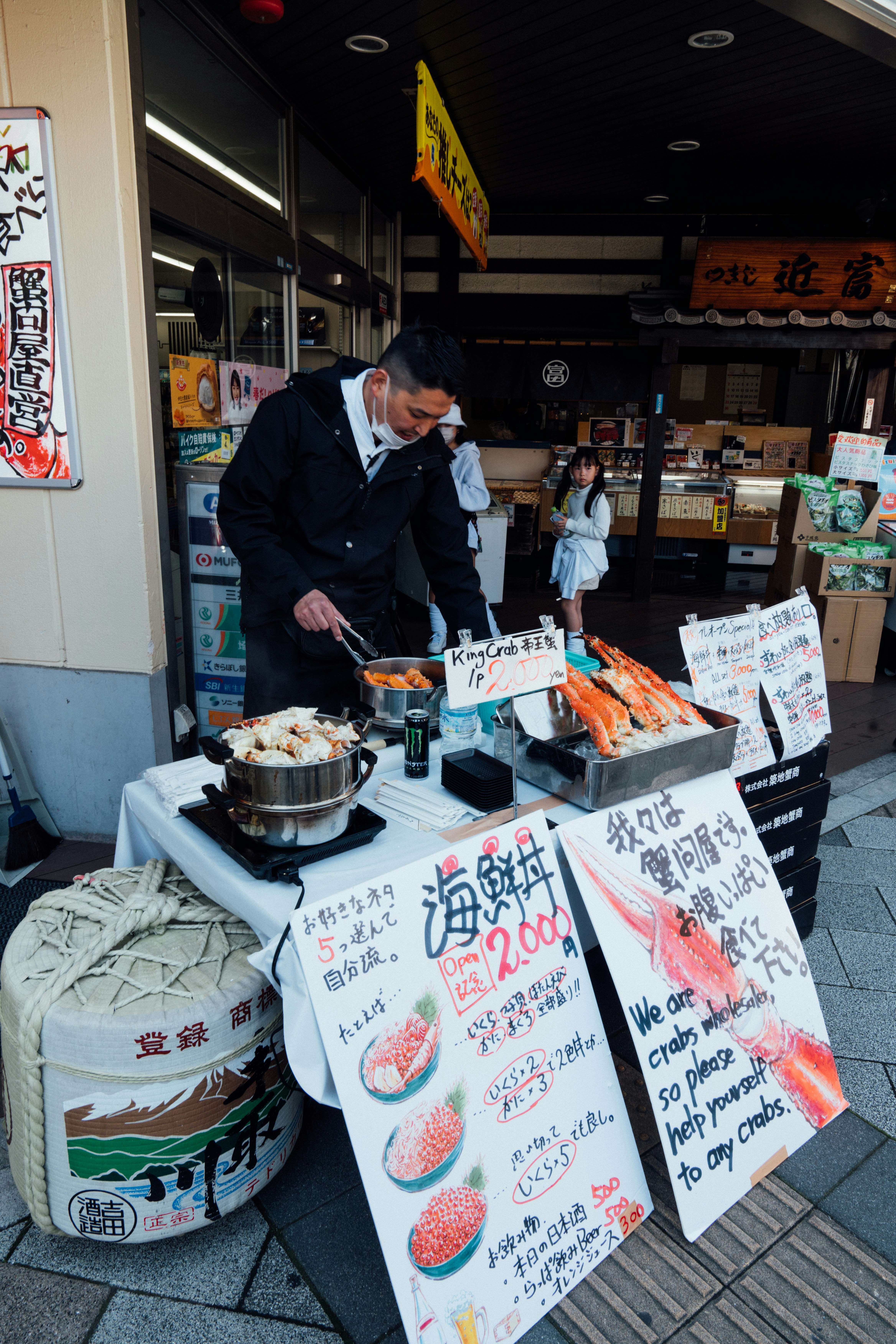 Un homme préparant de la nourriture sur une table devant un magasin