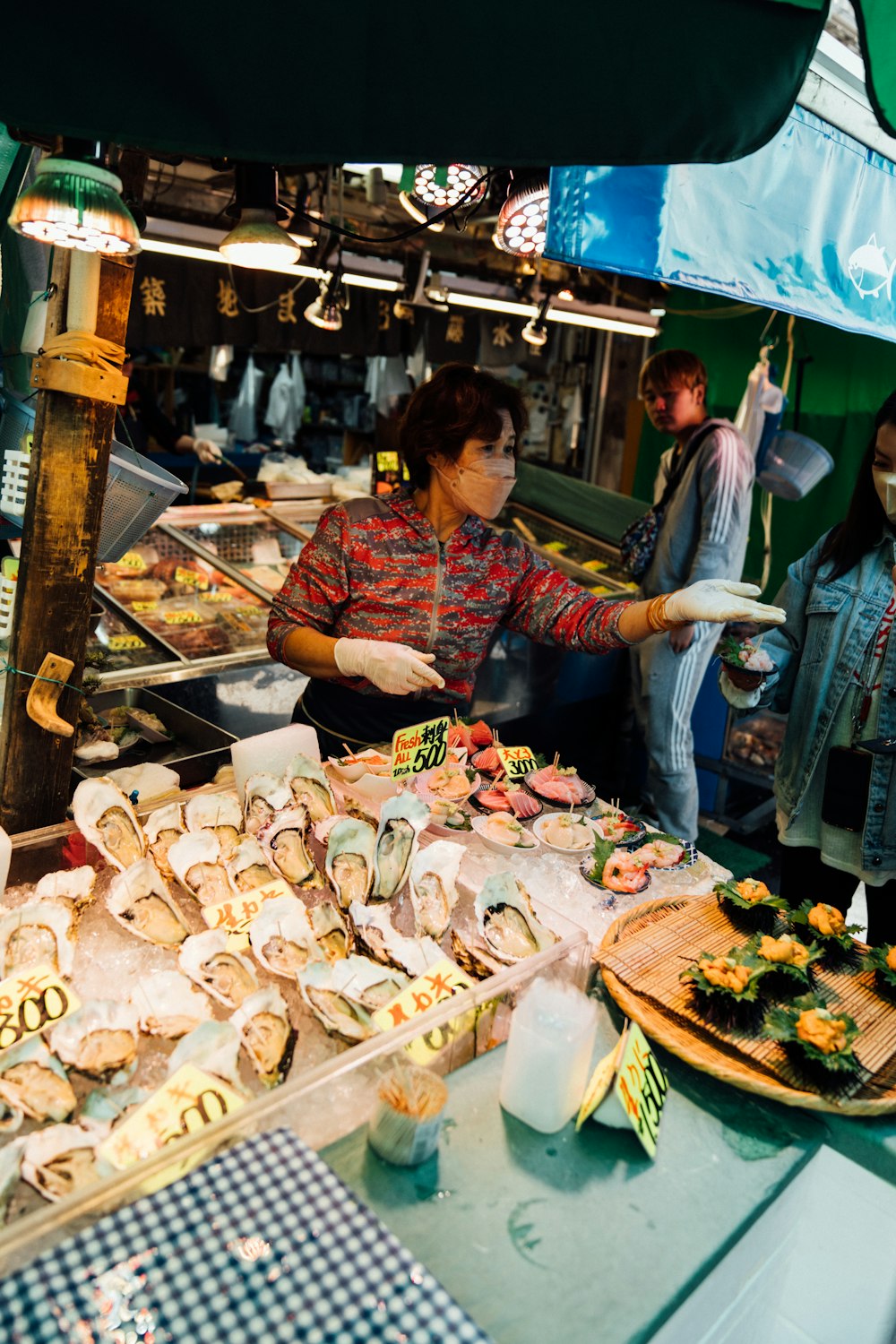 a woman standing in front of a counter filled with food