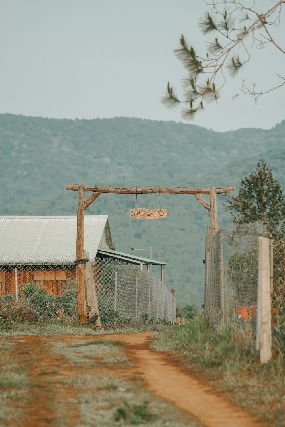 a dirt road leading to a building with a sign on it