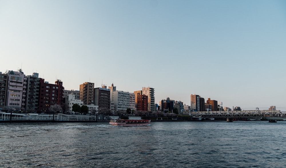 a boat traveling down a river next to tall buildings