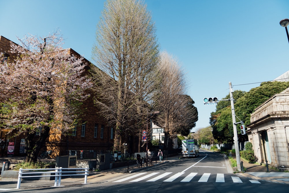 an empty street with a white fence and trees