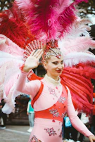 A candid backstage moment showing Billy adjusting a hot pink feathered costume piece.