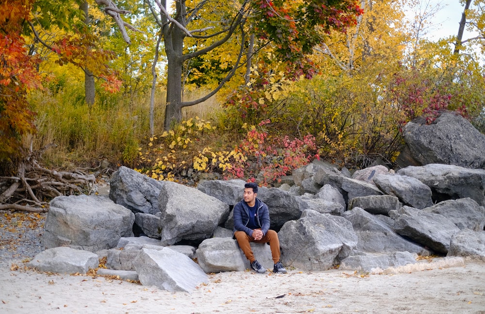 a man sitting on a pile of rocks