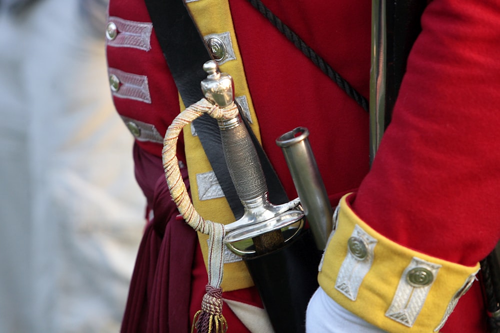 a close up of a person in a uniform holding a pipe