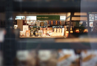 An office worker hurriedly grabbing supplies from a crowded store shelf.