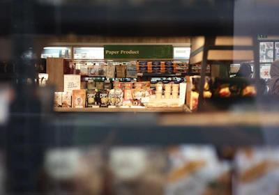 An office worker hurriedly grabbing supplies from a crowded store shelf.