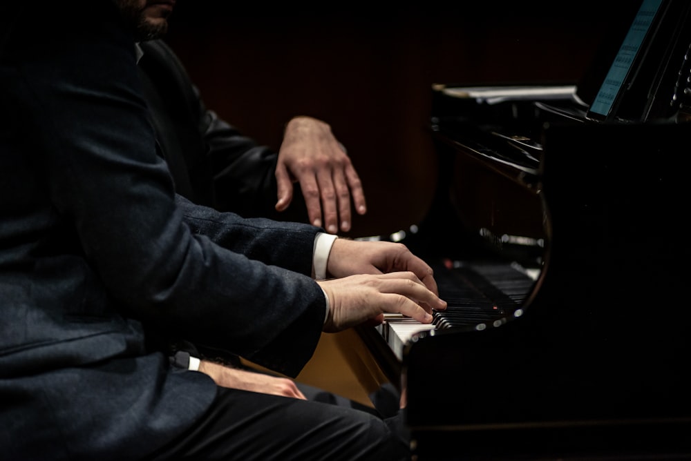 um homem em um terno que joga um piano
