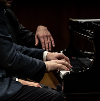 a man in a suit playing a piano