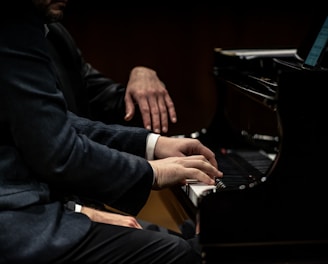 a man in a suit playing a piano