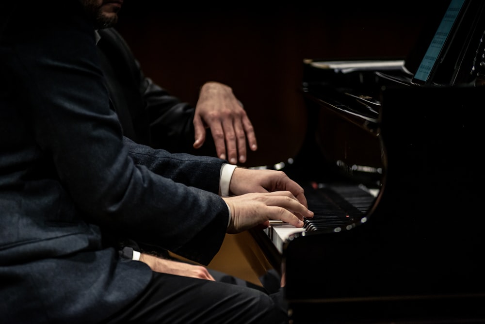 a man in a suit playing a piano