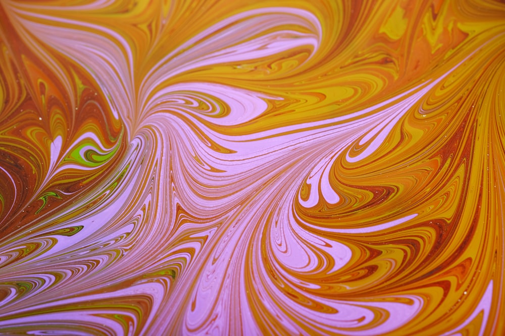 a close up view of a yellow and pink swirled surface