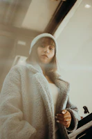 An adult wearing a stylish, comfortable outfit standing in a cozy home setting.
