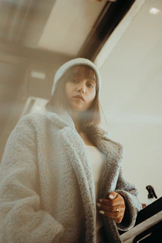 An adult wearing a stylish, comfortable outfit standing in a cozy home setting.
