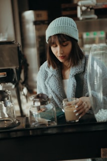 A cozy corner with a mannequin dressed in layered winter clothes next to a steaming cup of coffee.