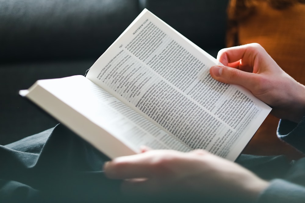 a person reading a book on a couch