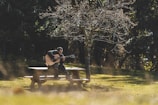a man sitting on a bench playing a guitar