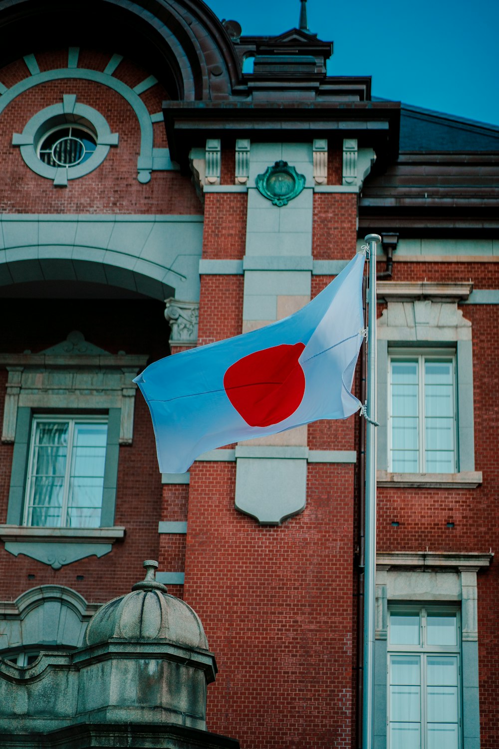 a japanese flag flying in front of a building