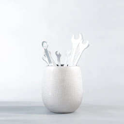 a white vase filled with lots of wrenches