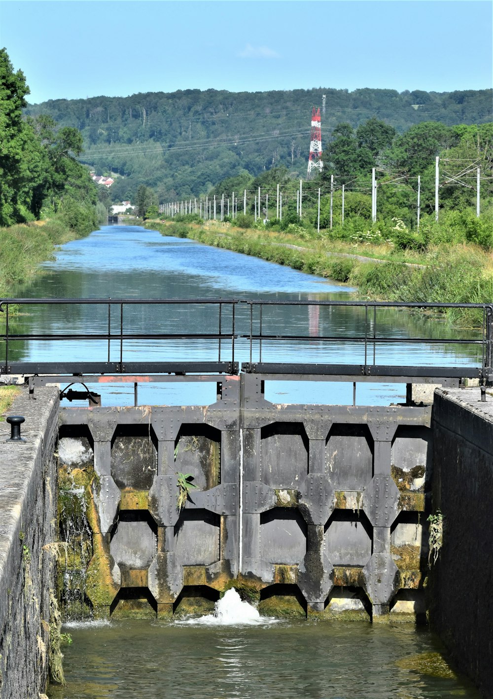 a man standing on top of a bridge next to a river