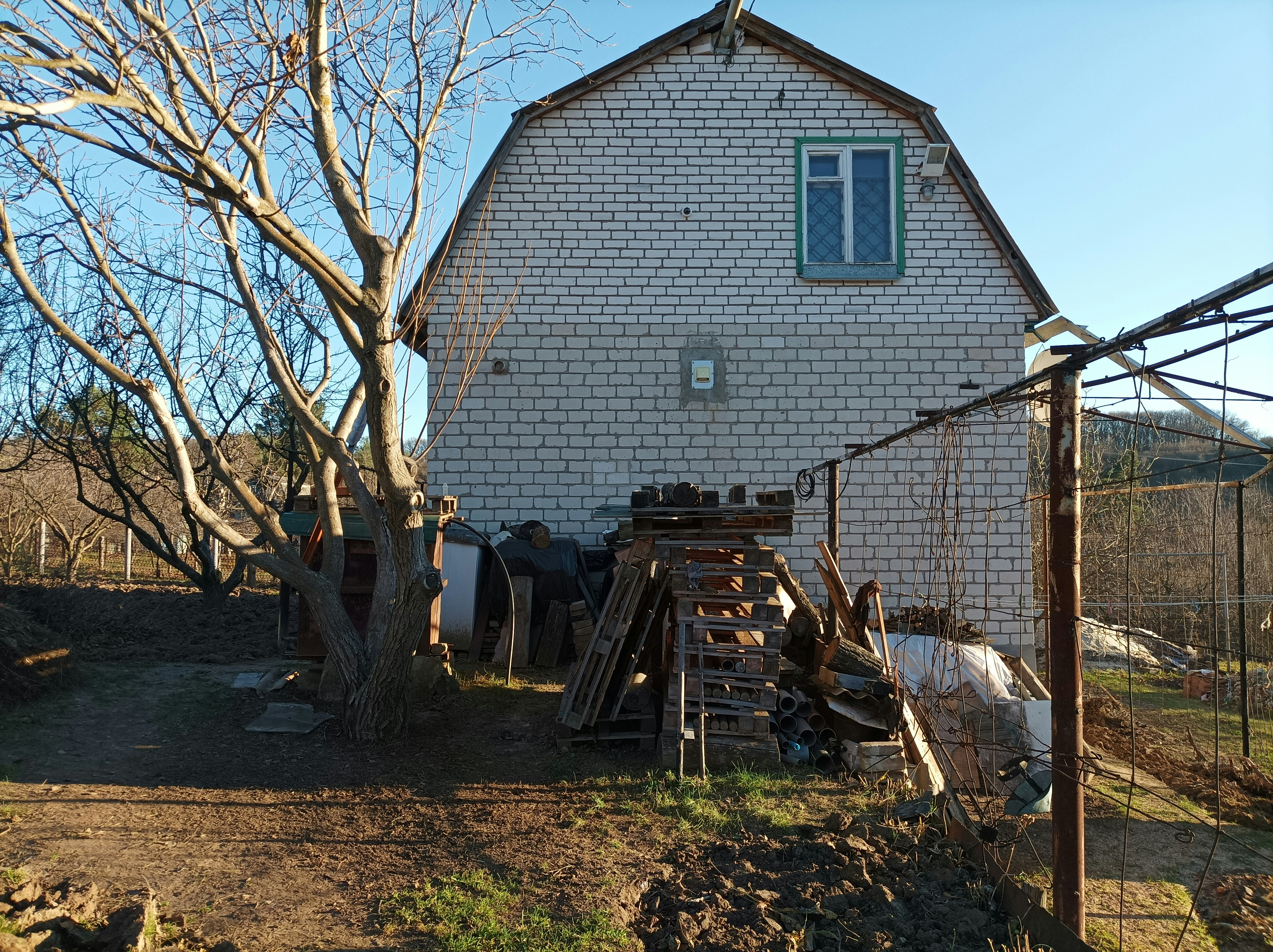 a barn with a bunch of junk in front of it