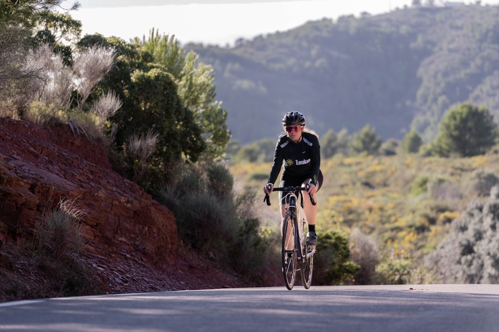 a man riding a bike down a curvy road