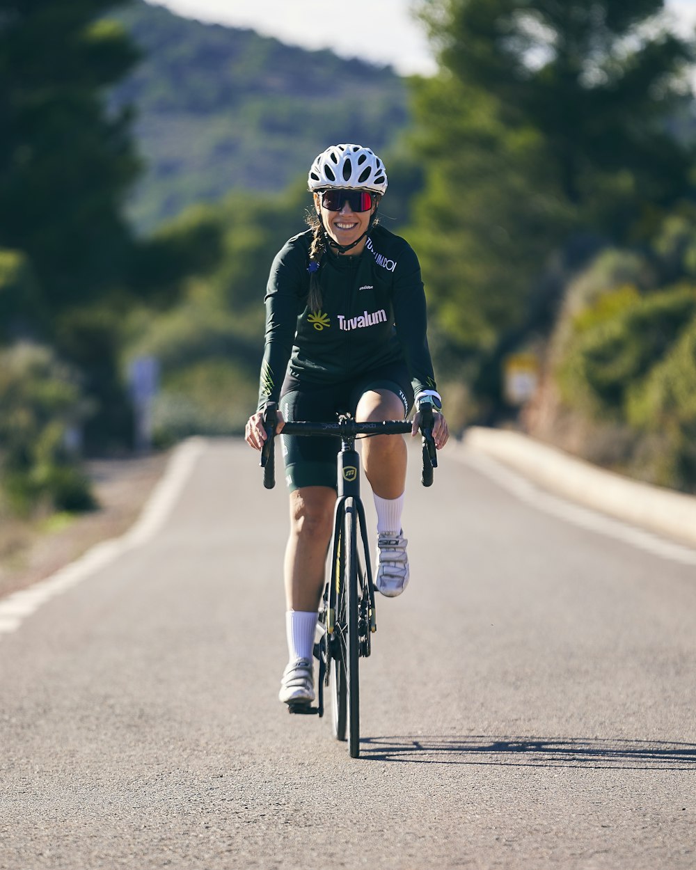 a woman riding a bike down a curvy road