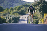 Cycling helmets and outdoor gear displayed against a backdrop of green hills.