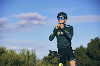 a man standing next to a bike in a field