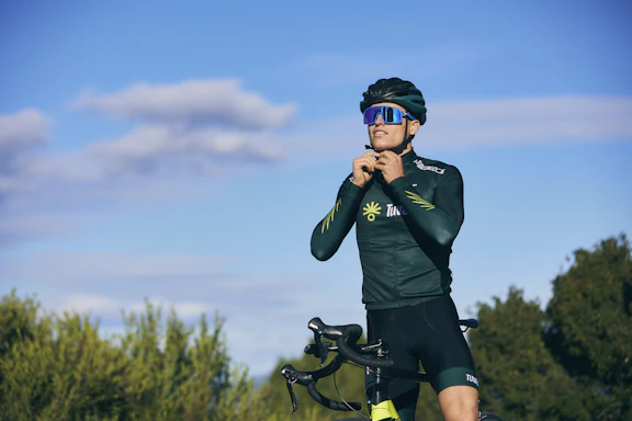 a man standing next to a bike in a field