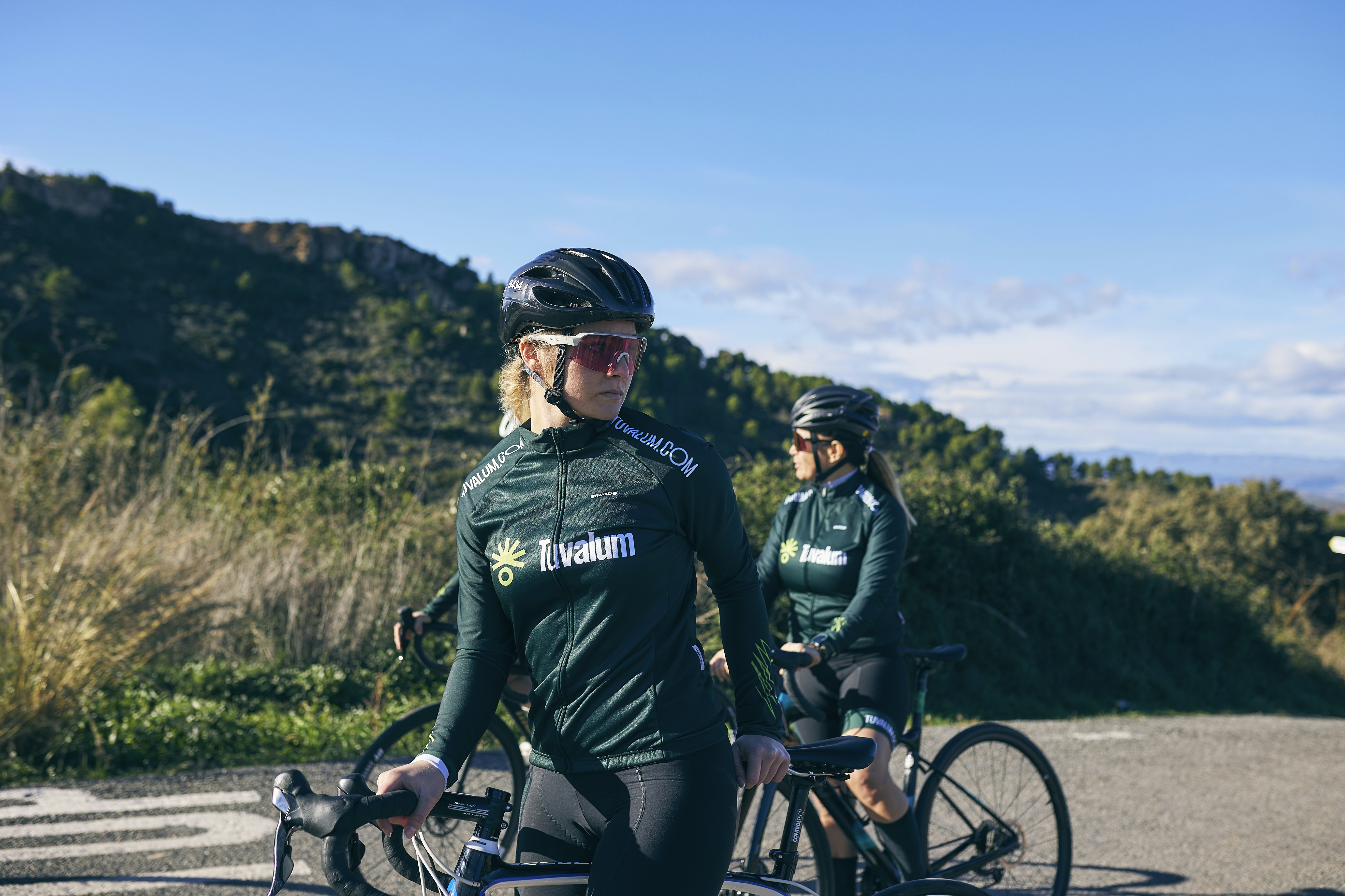 a couple of women riding bikes down a road