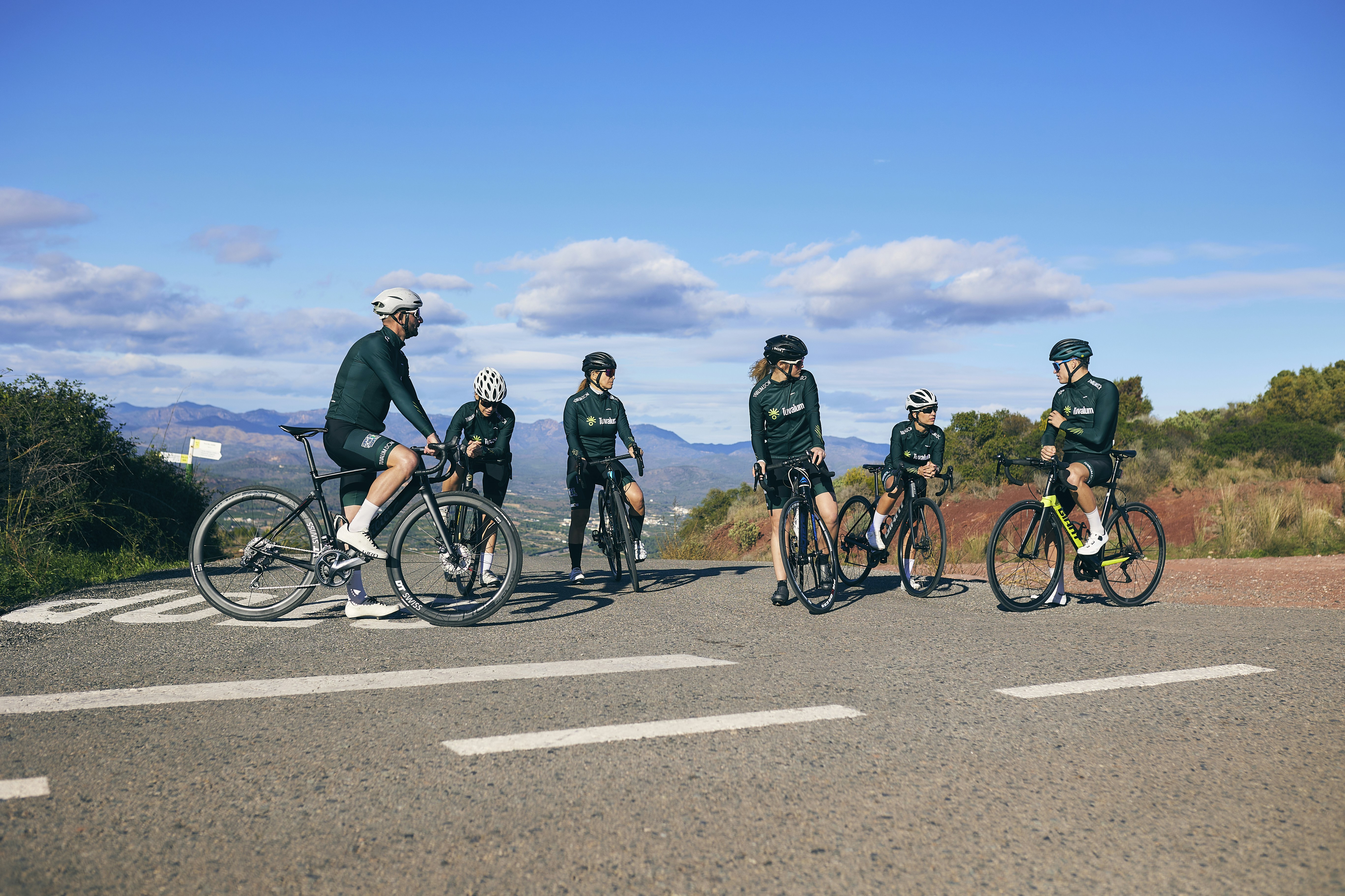 a group of people riding bikes on a road