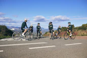 Group of cyclists resting beside a historic church in Acambay under a clear blue sky.